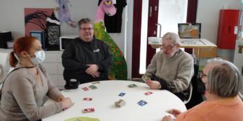 Marko pöydän ääressä pelaamassa kolmen muun ihmisen kanssa korttipeliä.