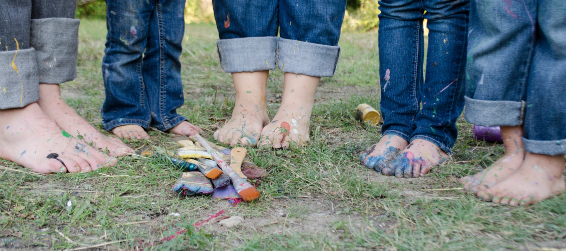 Lasten maalatut jalat nurmikolla.