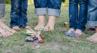 Lasten maalatut jalat nurmikolla.