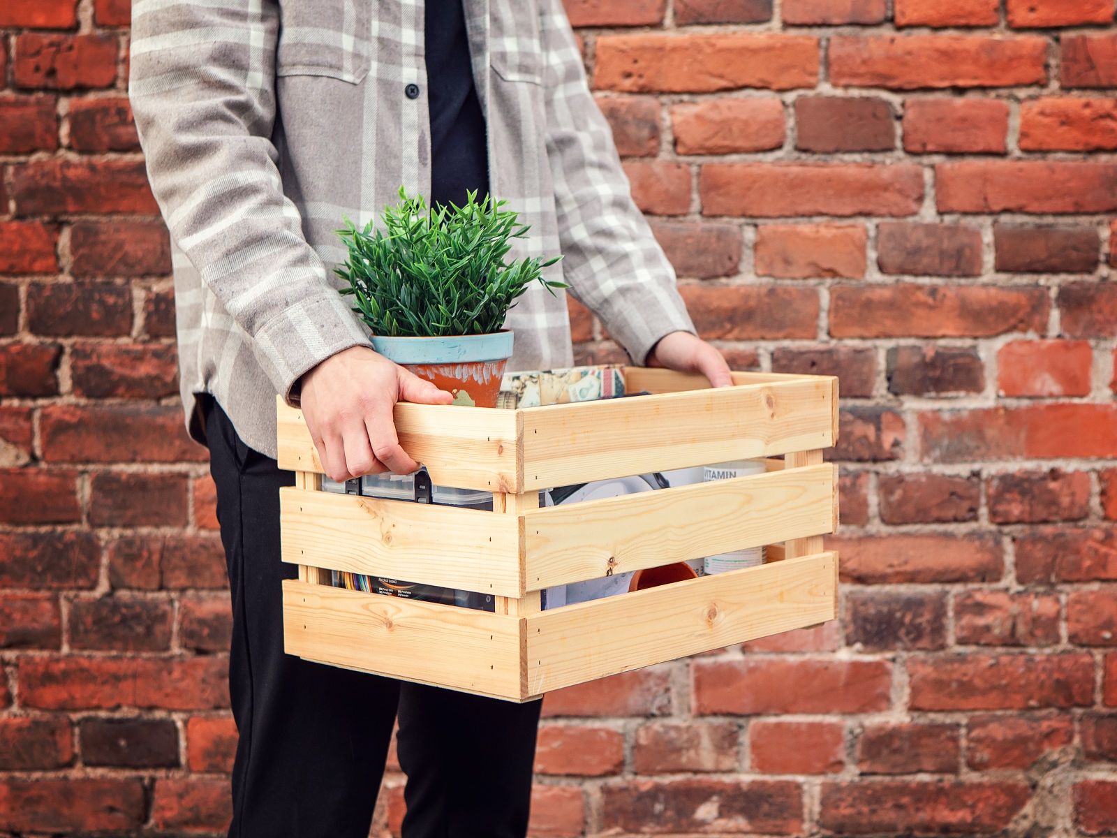 Muuttolaatikkoa kantavat kädet.