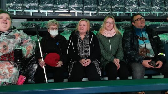 Kokemustoimijat areenan katsomossa.