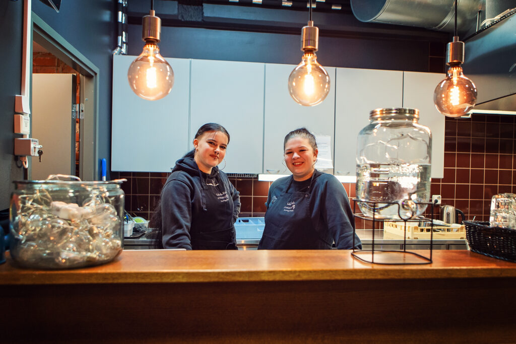 Kaksi hymyilevää nuorta.