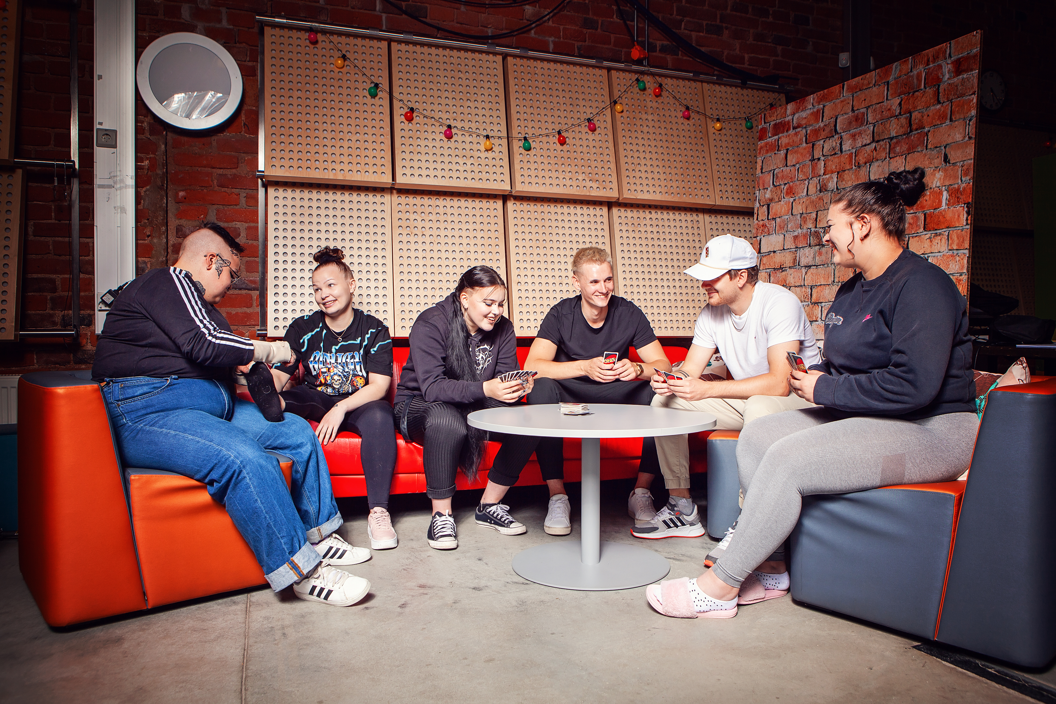 Kuusi nuorta pelaa lautapeliä.