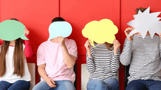 Neljä ihmistä, jotka pitävät puhekuplia kasvojensa edessä.