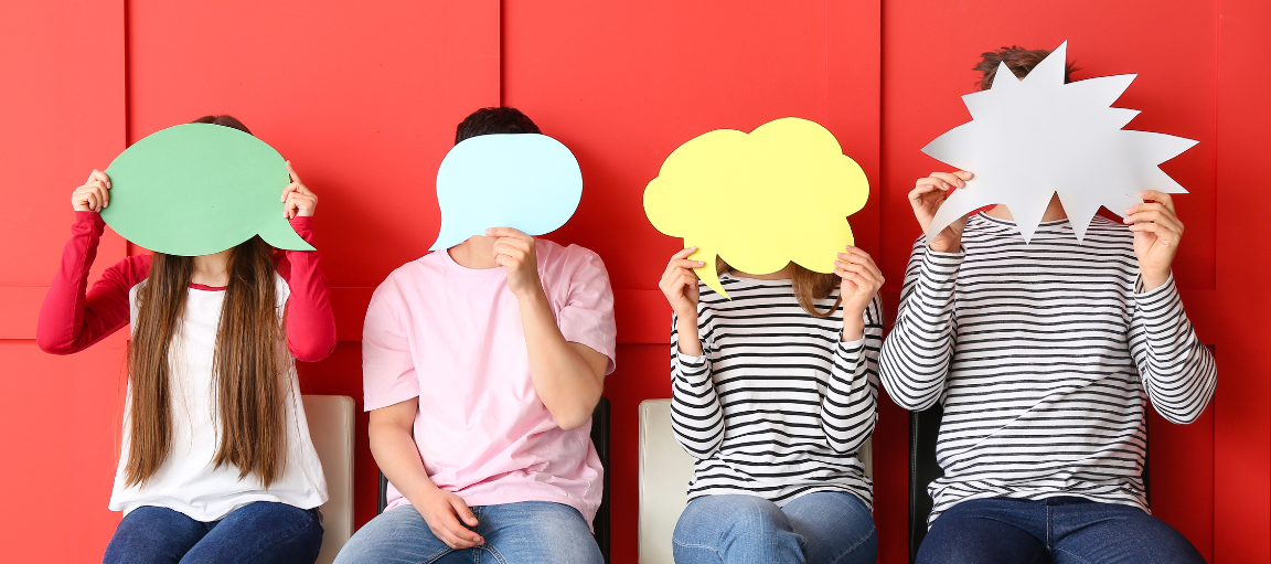 Neljä ihmistä, jotka pitävät puhekuplia kasvojensa edessä.