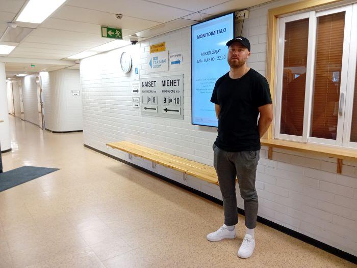 Mies seisoo monitoimitalon käytävällä.