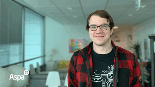 Nuori silmälasipäinen mies seisoo huoneessaan.