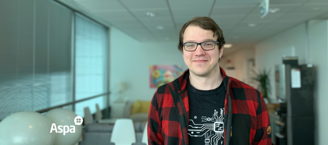 Nuori silmälasipäinen mies seisoo huoneessaan.